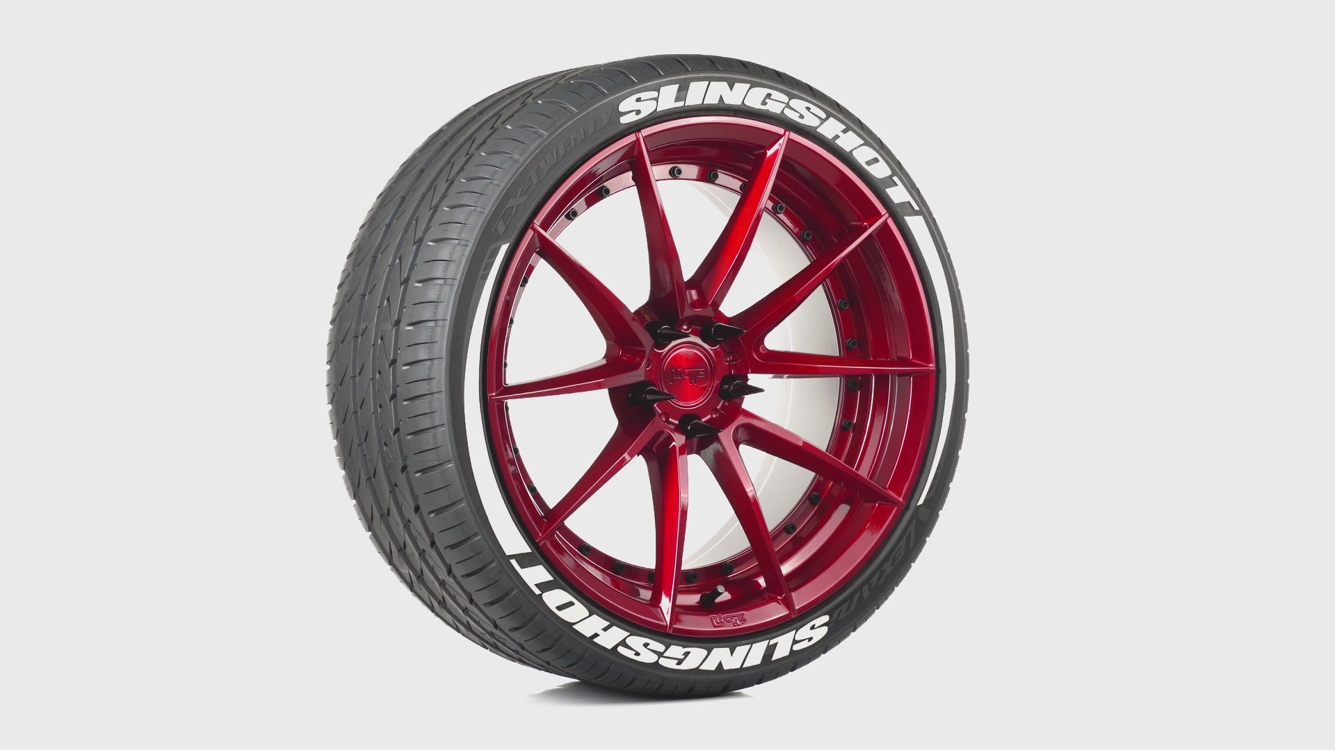 Candy apple red wheel with white tire lettering and black spike lug nuts